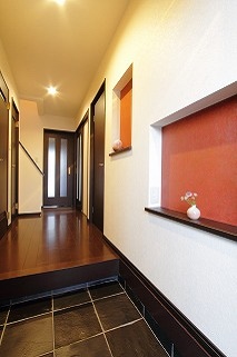 橙色の壁と飾り棚を備えた玄関
